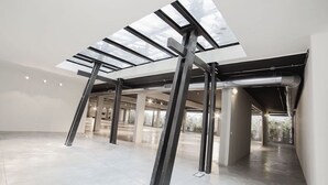 A spacious, modern interior with a high ceiling and skylights, featuring exposed structural beams and a clean, minimalist design. - Elegant house in the center of Rome-Parioli a stone's throw from Via Veneto (Roma)