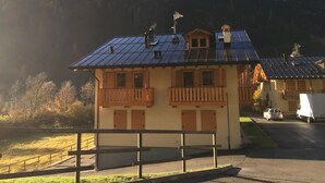 Un petit bâtiment d’un seul étage, doté d’un toit en pente, d’un balcon en bois et de panneaux solaires.