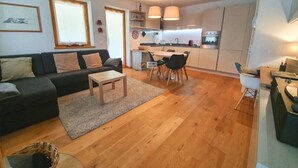 Un salon moderne avec un canapé, une table basse et un coin repas.