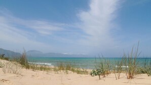 A beach with clear skies, calm sea, and distant mountains. - PRIVATE POOL 3 BEDROOMS 3 BATHROOMS 150 MT FROM THE SEA WI FI FREE , CAR RENTAL (CASTELLAMMARE DEL GOLFO)