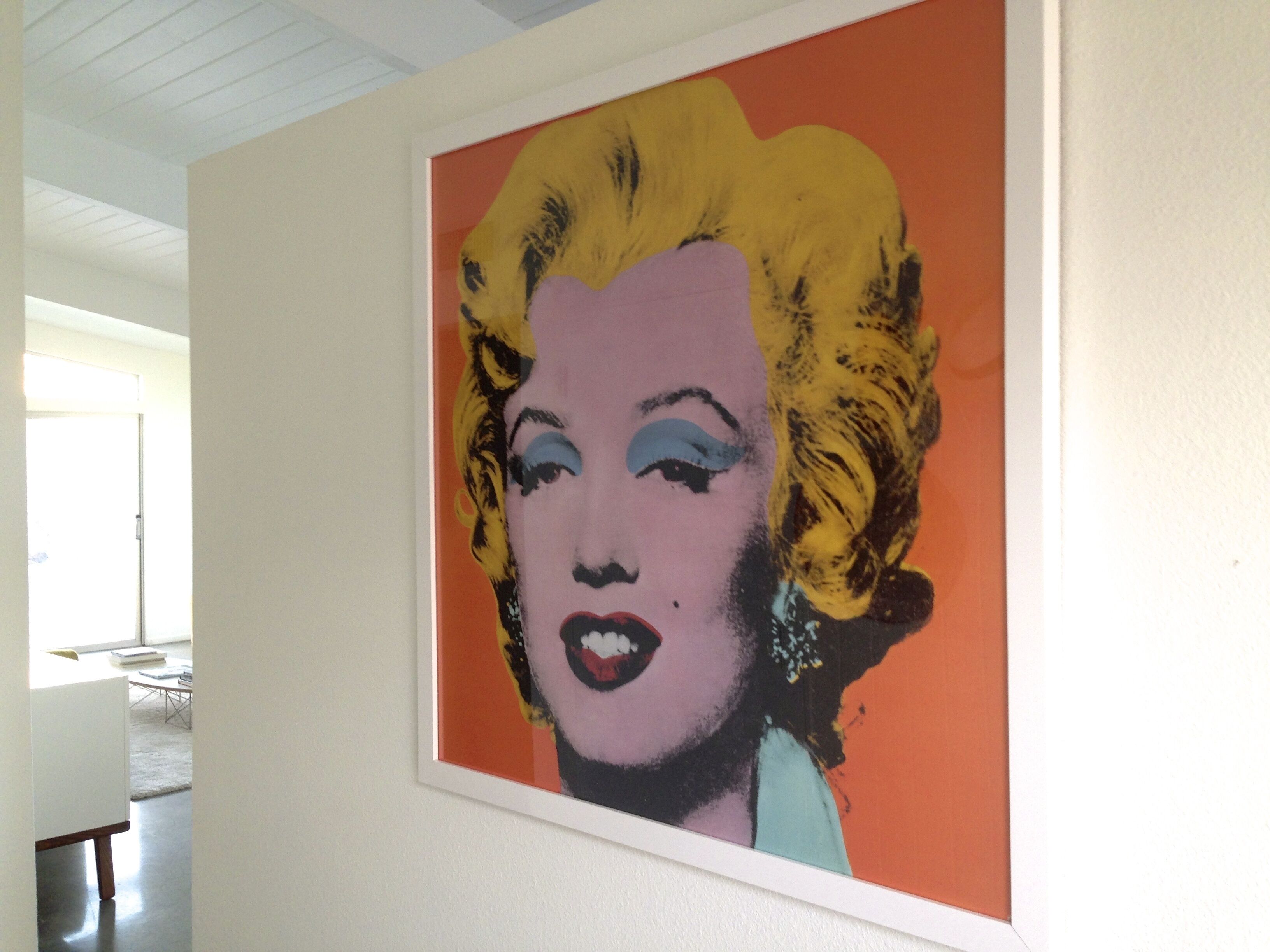 A framed pop art painting on a wall.