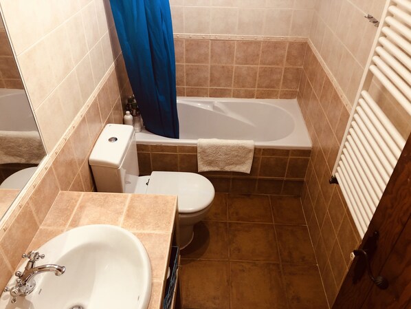 Ein Badezimmer mit Badewanne, Toilette und Waschbecken.