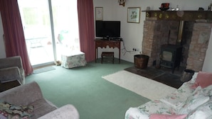 A living room with a fireplace, a television, and a sofa. - Tranquil country cottage set in the heart of a traditional family farm. (tenbury wells)
