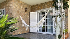 A stone exterior wall, a hammock, and a glass door. - Lagoa Albufeira House - with private swimming pool (Sesimbra)