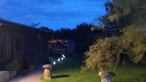 Ein Schotterweg führt zu einem Haus mit einem Steinpfeiler und einem kleinen Garten.