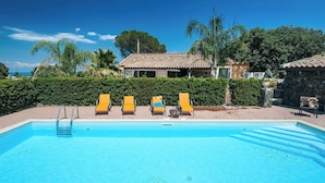 A swimming pool with three sun loungers, a ladder, and a stone wall in the background. - Country-house with pool and Etna and sea views (Acireale)