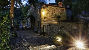 Un bâtiment rustique en pierre, doté d’une porte en bois et d’un petit porche.