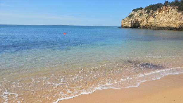 A beach with clear water, a sandy shore, and a cliff. - Tourist Set Alporchinhos (Armação de Pêra - Algarve)