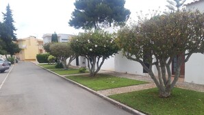 A residential street with houses, a paved road, and a sidewalk. - Tourist Set Alporchinhos (Armação de Pêra - Algarve)