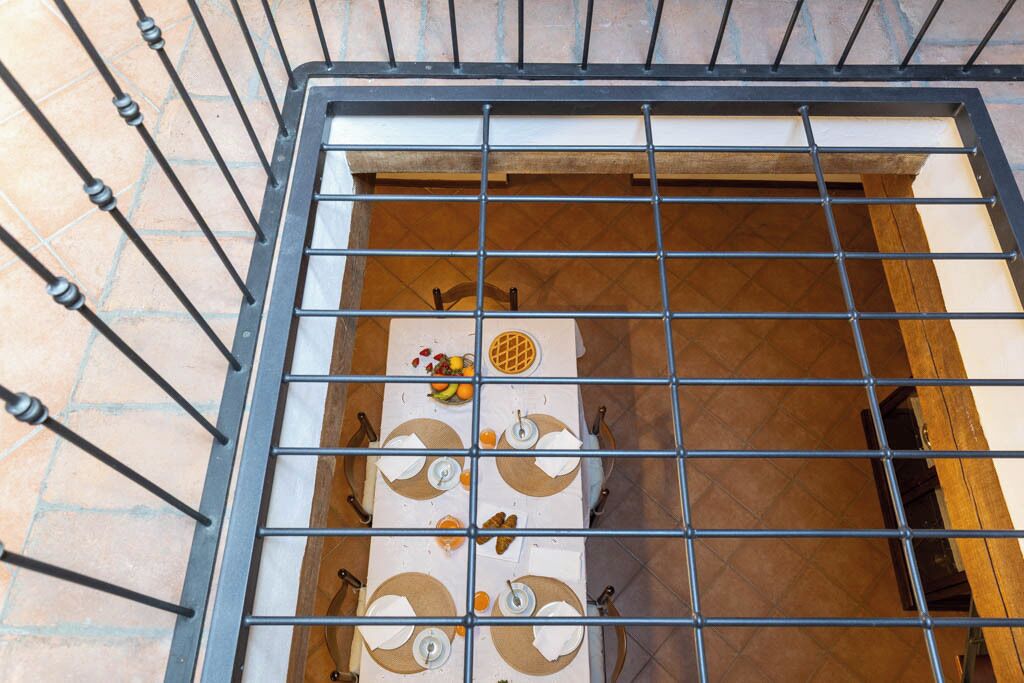 Un piso de baldosas con estructura metálica de rejilla, posiblemente un balcón o espacio cerrado.