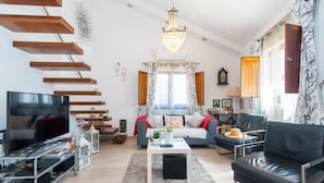 Ein modernes Wohnzimmer mit Fernseher, Sofa und Couchtisch.
