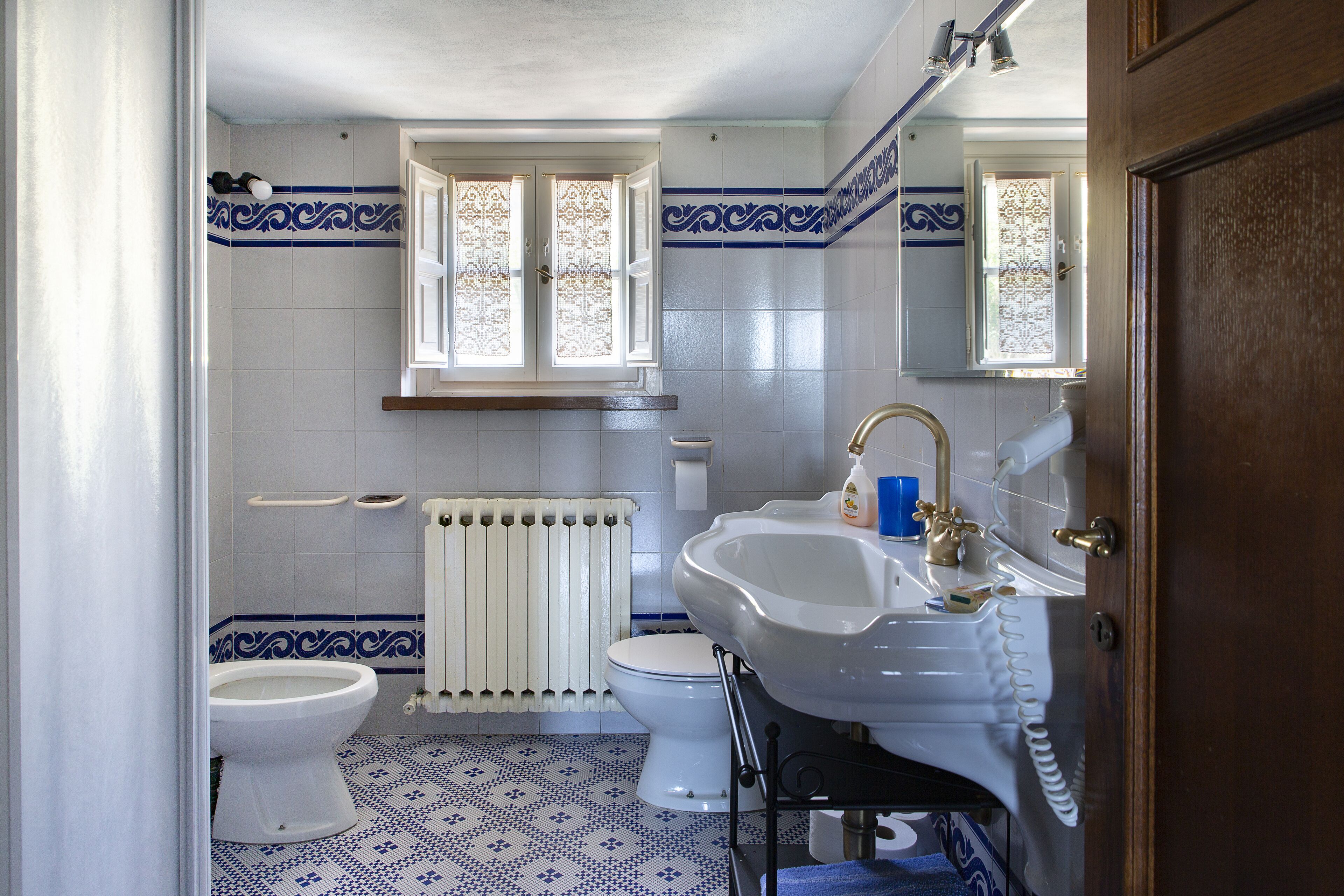 Une salle de bain avec des toilettes, un lavabo et une fenêtre.