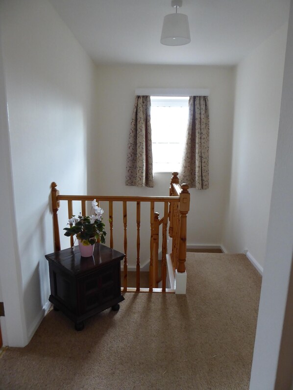A room with a wooden staircase, a small table with a potted plant, and a window with curtains. - Spacious House 3 ensuite bedrooms, sleeps 6, Centre of Helmsley, Pet friendly, (Helmsley)