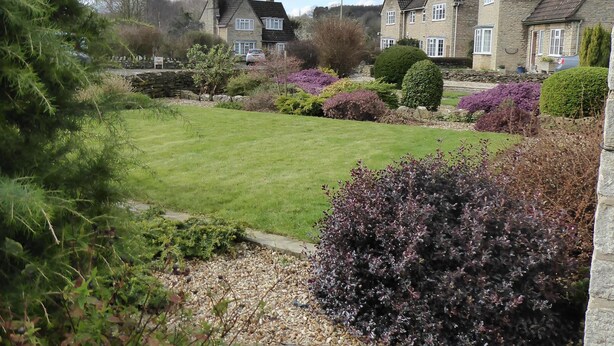 A residential area with stone houses, a well-maintained lawn, and various shrubs. - Spacious House 3 ensuite bedrooms, sleeps 6, Centre of Helmsley, Pet friendly,  (Helmsley)