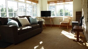 A living room with a sofa, a chair, a television, and a fireplace. - Spacious House 3 ensuite bedrooms, sleeps 6, Centre of Helmsley, Pet friendly,  (Helmsley)