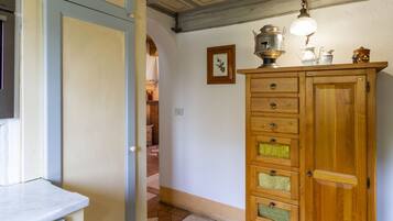 A wooden cabinet with multiple drawers and a hanging light fixture.