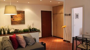 A modern living room with a sofa, a dining table, and a lamp. - 80m², Todo Reformado, Fibra Wifi, Estação Central, Metrô a Poucos Minutos (Milano)