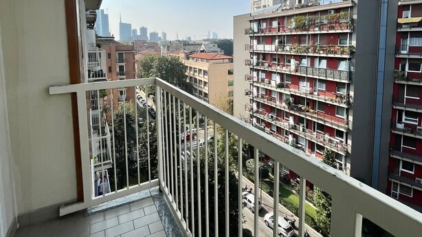 A balcony with a view of a cityscape, including multi-story buildings and a clear sky. - 80m², Todo Reformado, Fibra Wifi, Estação Central, Metrô a Poucos Minutos (Milano)