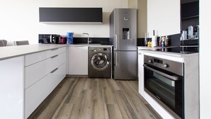 A modern kitchen with a built-in washer and dryer, a refrigerator, and an oven. - 3-star vacation rental. Large private balcony. Ocean View—Parking—Beach Access (Cassis)