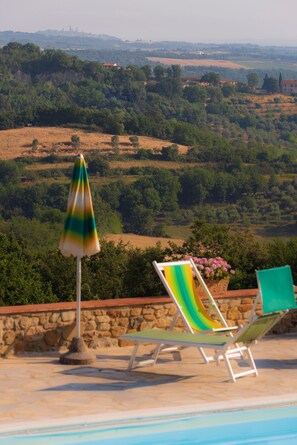 Alberca al aire libre y camastros 