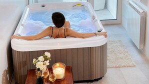 A person relaxing in a hot tub with a view of outdoor furniture and greenery. -  Villa antico pozzo: pool, spa, sauna, sea view, 15 minutes from Scopello (Castellammare del Golfo)