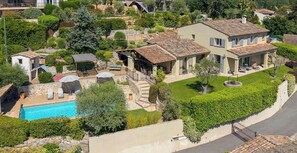 A residential property with a swimming pool, multiple buildings, and a well-maintained garden.