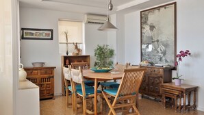 A dining area with a wooden table, chairs, and a hanging light fixture. - Flat in Benidorm Renovated Frontline with Terrace (Benidorm)