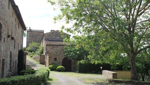 Un bâtiment en pierre avec un chemin de gravier menant à une porte en bois.