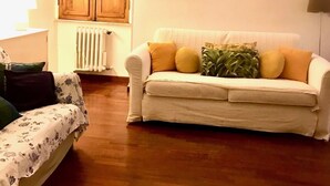 A living room with a sofa, a wooden cabinet, and a radiator.