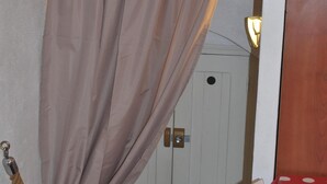 A room with a wooden cabinet, a white door, and a table with a polka dot tablecloth. - Apartment/ flat - Bonifacio (Bonifacio)