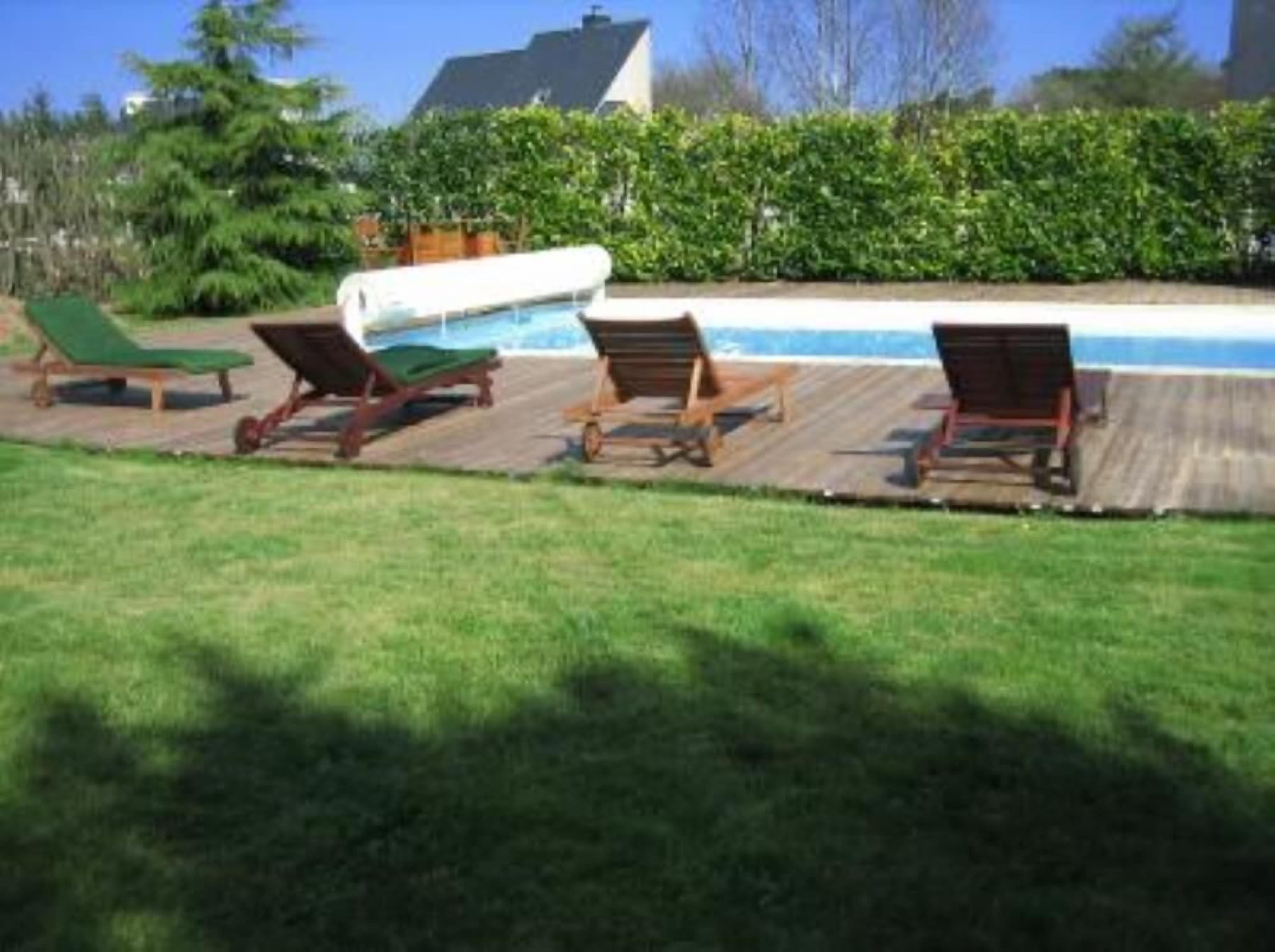 A poolside area with lounge chairs and a pool.