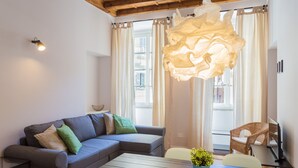 Uma sala de estar moderna com um sofá seccional cinza, uma mesa de centro de madeira e uma cadeira de vime.