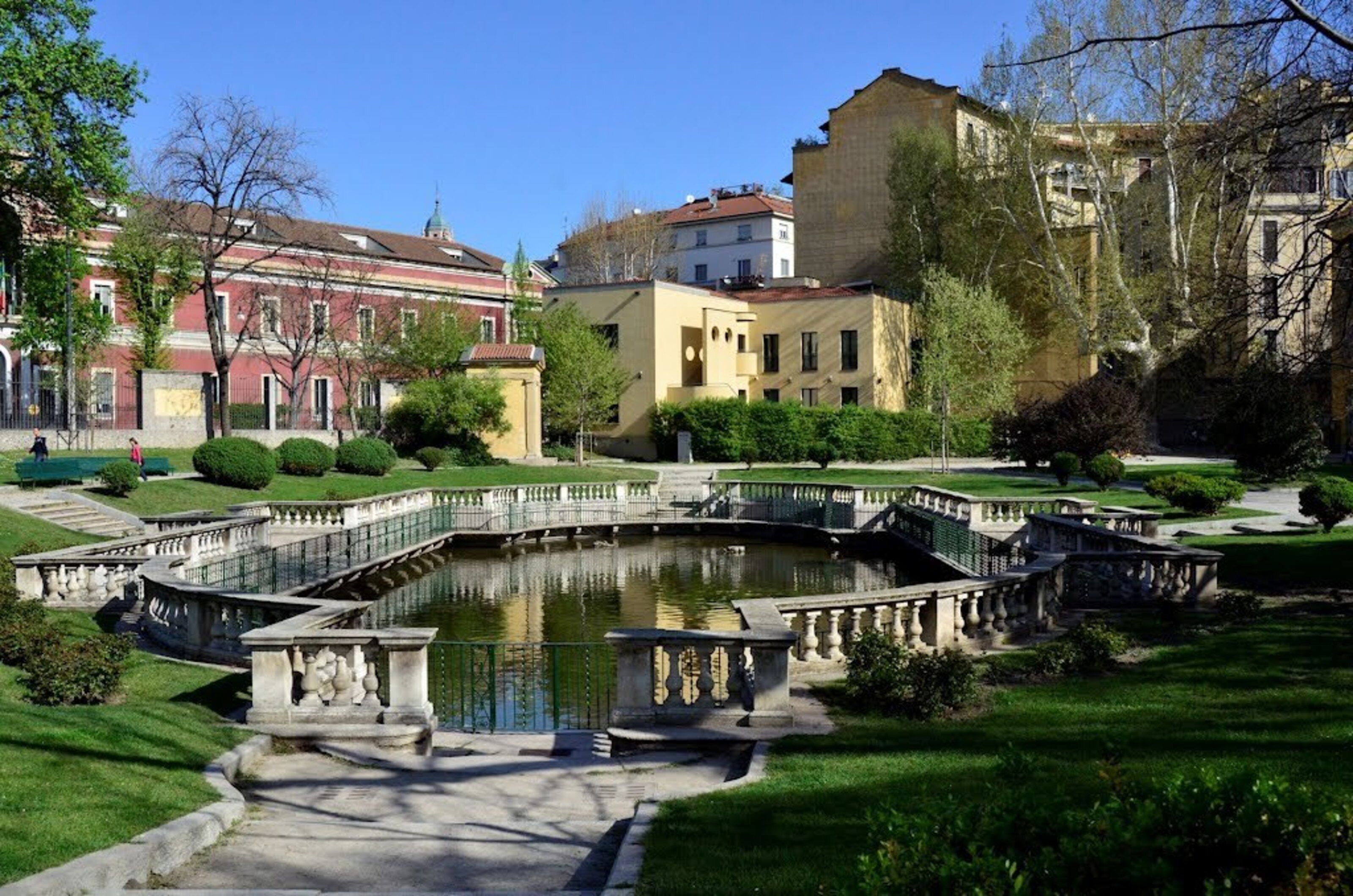 Un bâtiment historique à l’architecture classique, doté d’une fontaine centrale et de jardins bien entretenus.