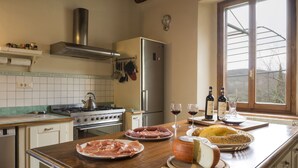 Una cocina equipada con estufa, horno, refrigerador y una ventana con vistas.