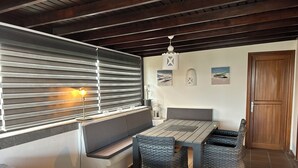 A cozy room with a wooden ceiling, a dining table with chairs, a bench, and a sofa. - Luxury villa - private pool with towels, super fast wifi, multiple language TV (Playa Blanca)