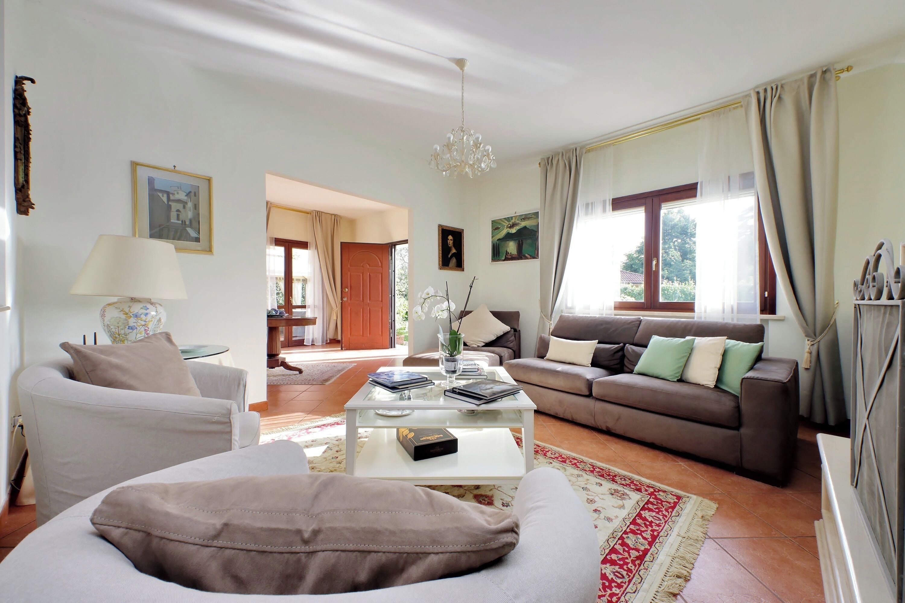 A living room with a sofa, a coffee table, and a couch. There is a door leading to another room.