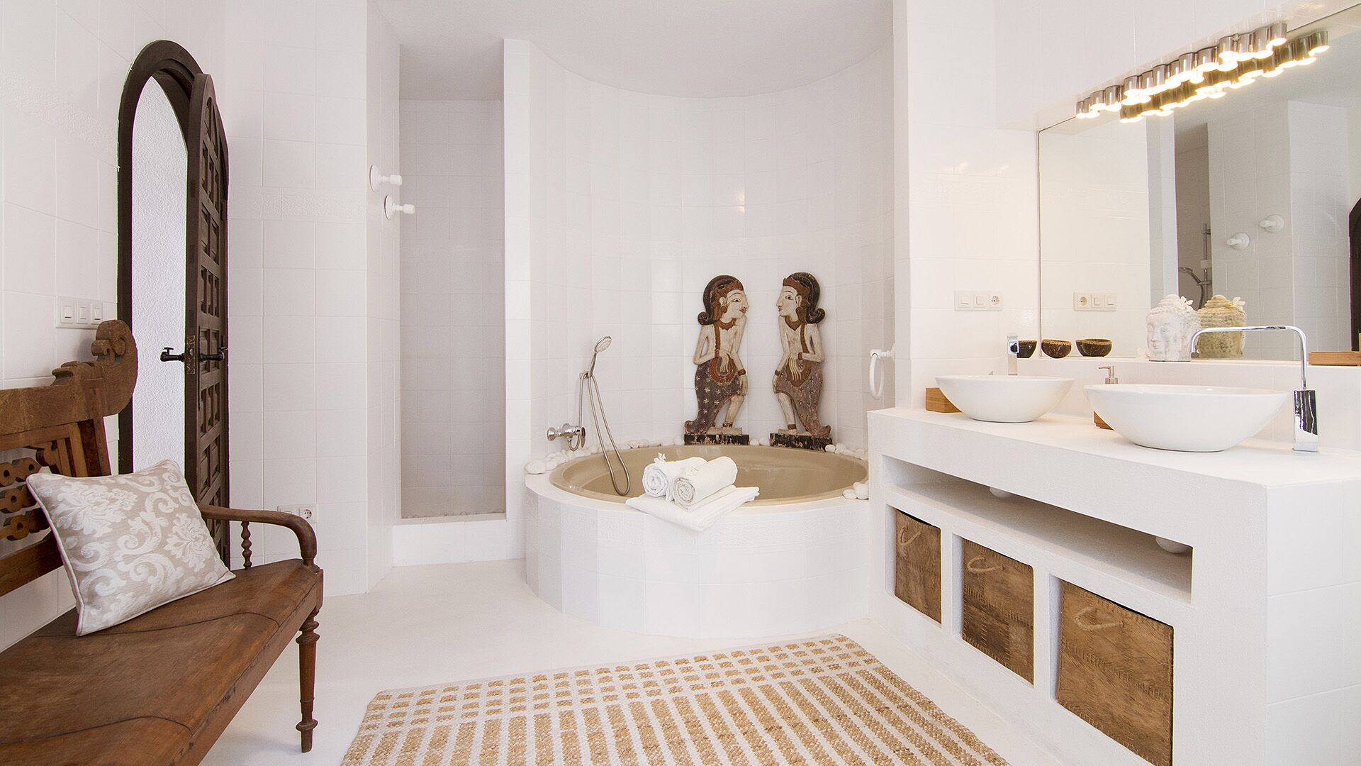 Une salle de bain moderne avec une baignoire îlot, un meuble-lavabo doté de deux vasques et un grand miroir avec éclairage intégré.