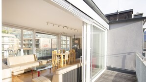 Een moderne woonkamer met een bank, salontafel en eethoek.