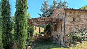 A stone building with a pergola in a garden. - It's pure magic! Dont' miss this unique chance...a beautiful view and an exclusive stay will take yo (Serrapetrona)