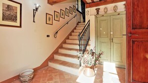 A staircase with a handrail, a green door, and a wall with framed pictures. - It's pure magic! Dont' miss this unique chance...a beautiful view and an exclusive stay will take yo (Serrapetrona)