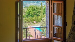 A room with a view of a swimming pool, a stone wall, and a small garden area. - Montebendico 6, Emma Villas (Montegiovi - Castel del Piano (Grosseto))