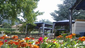 A garden with various flowers and a gazebo structure. - By: An hour from VENICE, in the park of the Colli Euganei - Tourist Locations (Vò)
