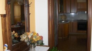 A hallway leading to a kitchen with wooden cabinets and a tiled backsplash. - By: An hour from VENICE, in the park of the Colli Euganei - Tourist Locations (Vò)