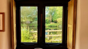 A room with a window overlooking a garden.