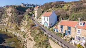 A coastal village with stone houses, a narrow road, and a river.
