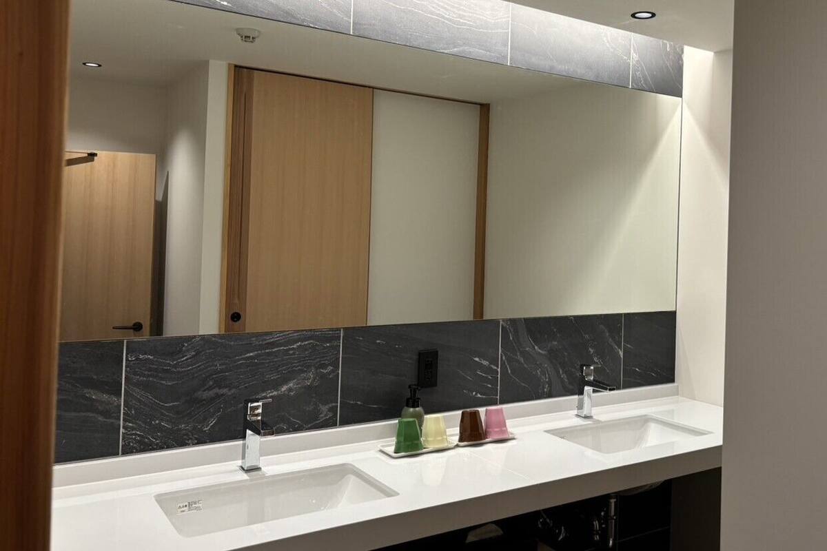 A bathroom with two sinks, a mirror, and a wooden door.