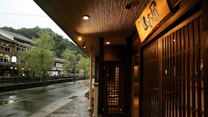Un edificio japonés tradicional con fachada de madera y entrada empedrada.