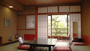 Una habitación tradicional japonesa con suelo de tatami, una mesa baja y puertas correderas shoji.