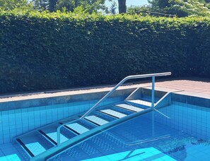 A swimming pool with a metal ladder and tiled steps. - A Pleasant Stay at " Logies Taverne." nearby Roermond, Thorn / Pool & Garden     (Kelpen-Oler)