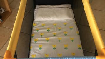 A comfortable crib with a floral-patterned mattress is available for guests.